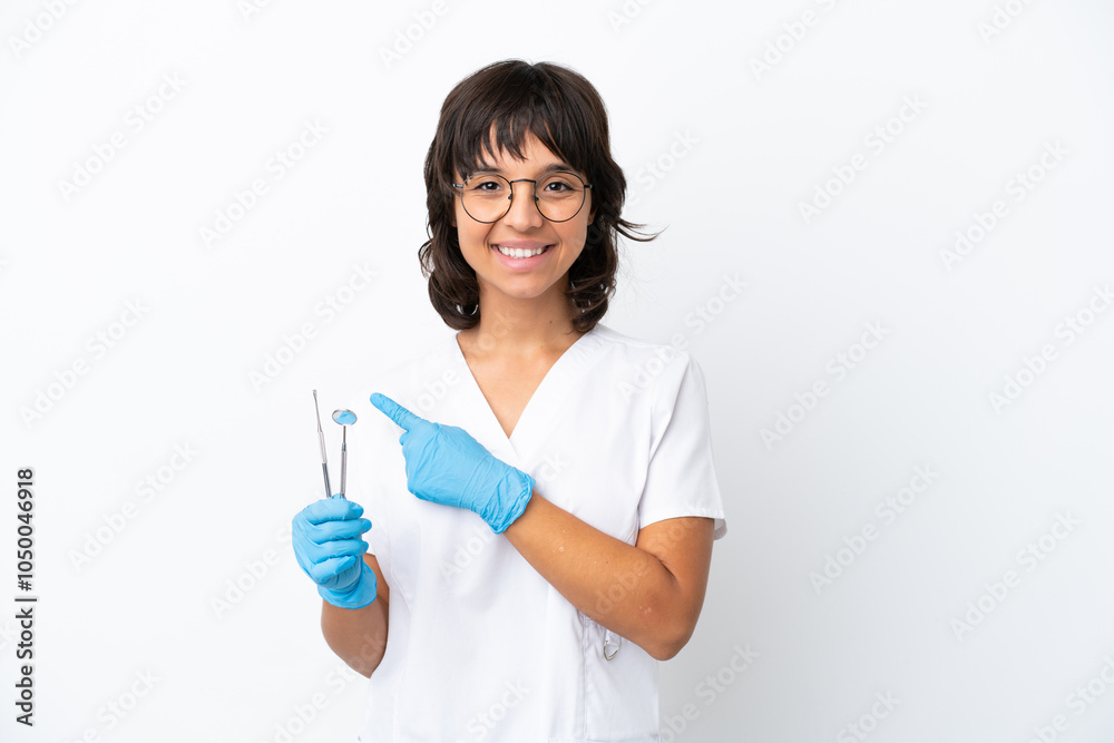 Young woman holding tools isolated on white background pointing to the side to present a product Young woman holding tools isolated on white background pointing to the side to present a product