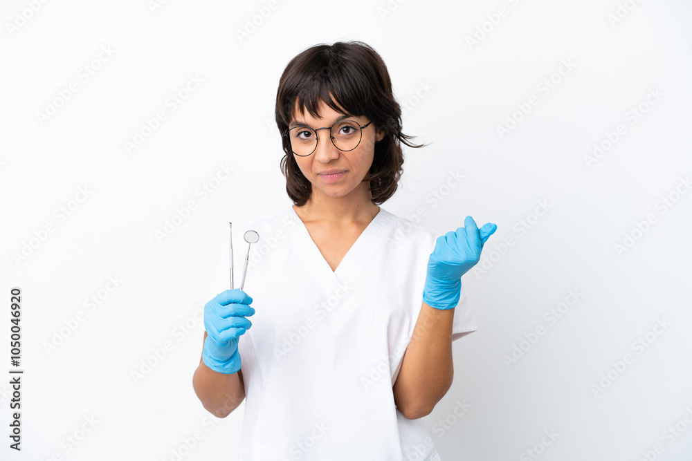 Young woman holding tools isolated on white background making money gesture Young woman holding tools isolated on white background making money gesture