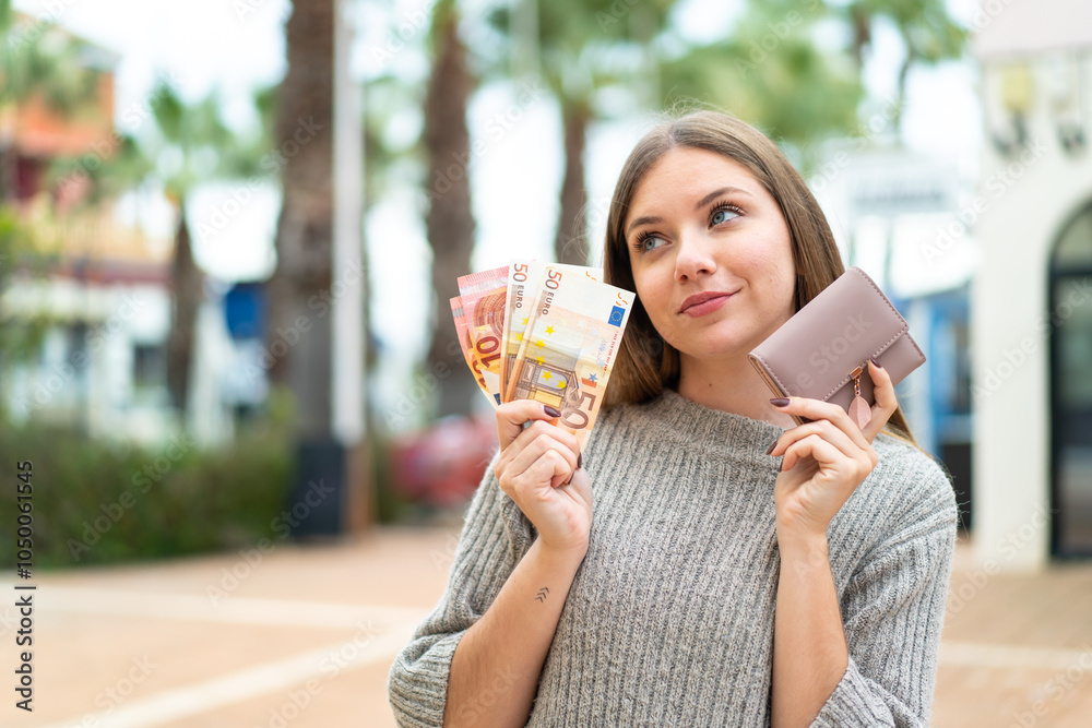 Φωτογραφία Young pretty blonde woman holding wallet and credit card