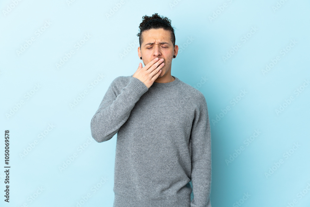 Caucasian man over isolated background yawning and covering wide open mouth with hand Caucasian man over isolated background yawning and covering wide open mouth with hand