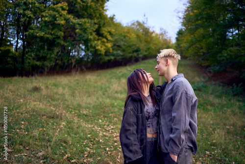 two 15-year-old teenagers in love play, hug, spend time together in an autumn park