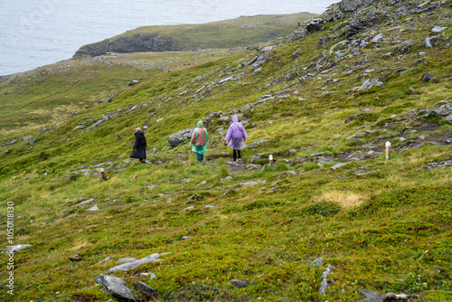 Skarsvag, Norway - 07.03.2024: Tourists on a trail to Kirkeporten in Norway photo