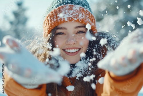 A girl in colorful winter attire throws snow joyfully into the air, capturing a moment of playful bliss and the simple pleasures of a snowy day. photo