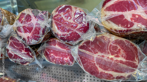Several cuts of marbled meat encased in vacuum-sealed packaging at a deli, illustrating food preservation and quality freshness
