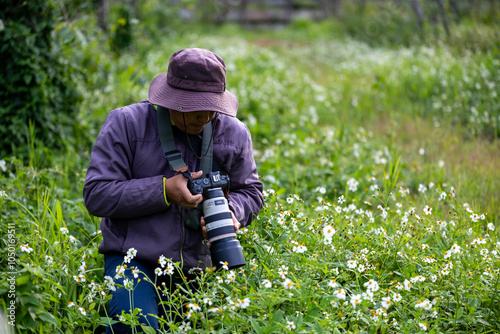 Photographer is taking photo while exploring the woodland forest with wild flower meadow for surveying and locating rare biological diversity and ecologist on field study