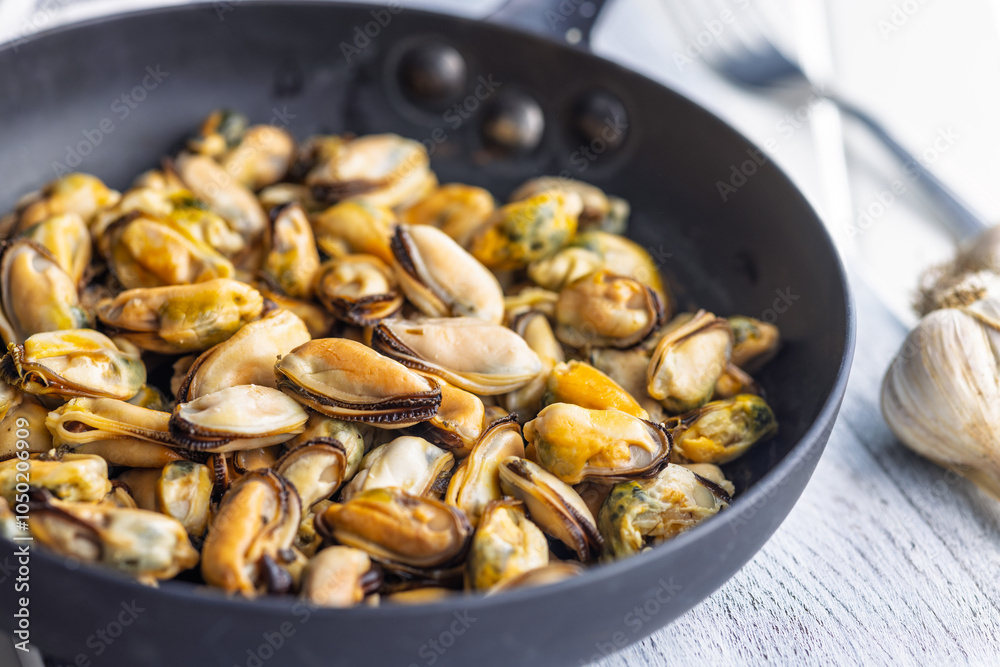 Shelled mussels meat in pan on white table Shelled mussels meat in pan on white table