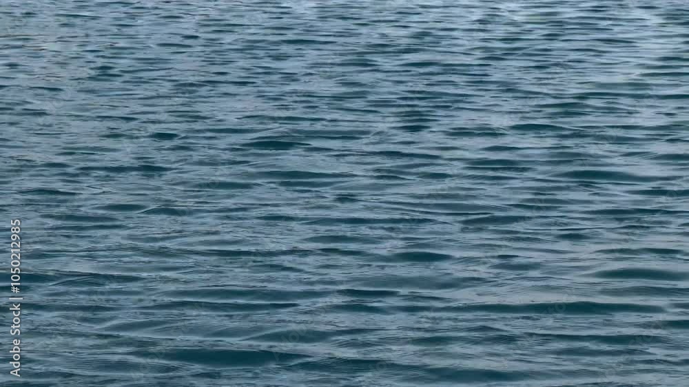 blue water surface with ripples, ripples on the water, Closeup footage of the water surface with sun light. blue water surface with ripples, ripples on the water, Closeup footage of the water surface with sun light.