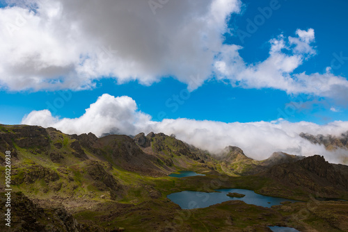 Lake and mountain ranges with rolling clouds over the peaks. Landscape photo photo