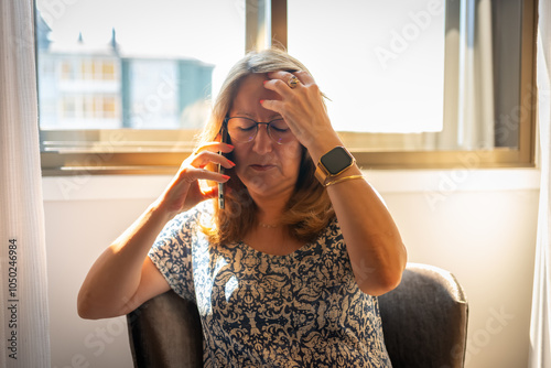 Billede på lærred A mature woman talking on the phone and with a worried face about the bad news s