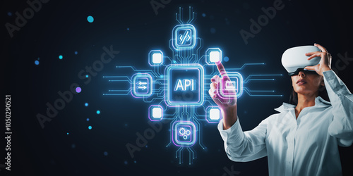 Woman interacting with holographic API icons wearing VR headset on dark backg...
