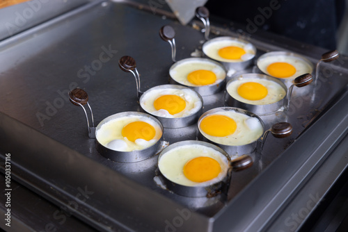 A pan of eggs is being cooked on a stove.