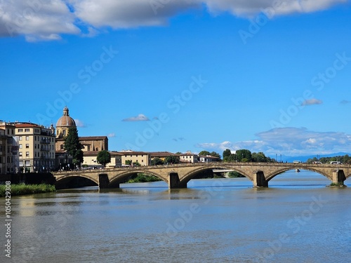 Florence, Italy - October 5, 2024: Discovering the city of Florence in autumn days. Frome the Duomo to Ponte Vecchio, old architecture covering the city. Beautiful sky reflected over Arno river.