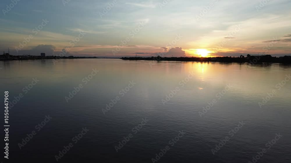 Drone View Sunset reflecting over a calm lake and river with orange skies and clouds Drone View Sunset reflecting over a calm lake and river with orange skies and clouds
