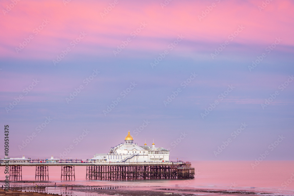 Fototapeta premium Lilac skies over Eastbourne Pier at low tide and sunset east Sussex south east England UK