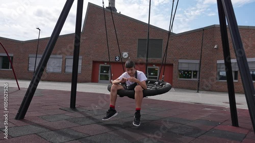Boy with autism Asperger syndrome having leisure outdoor. Upset teenager with mental disability playing alone in the schoolyard. photo