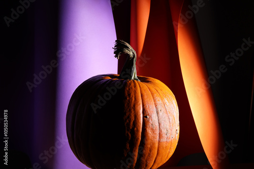 Zucca arancio isolata su fondo bicolore arancio e viola photo