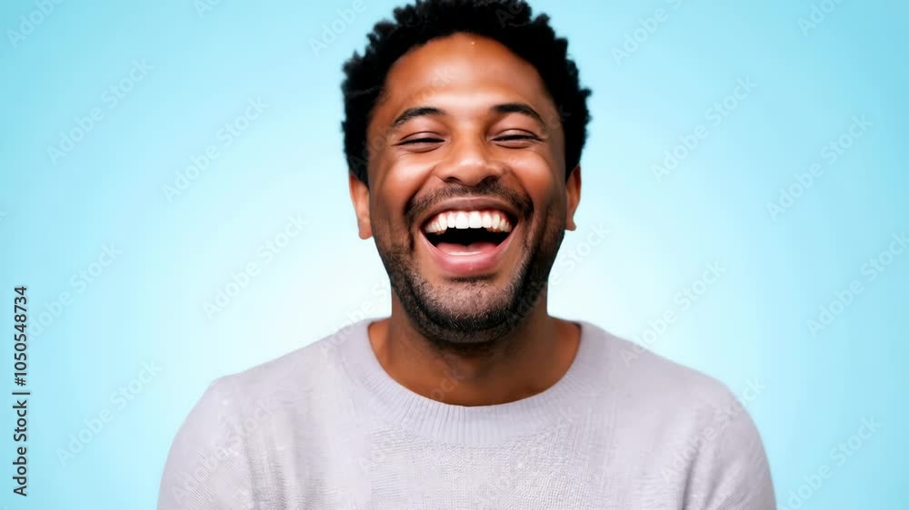 Joyful man smiling and laughing against light blue background, radiating happiness and positivity, with cheerful expression that conveys warmth and friendliness. Joyful man smiling and laughing against light blue background, radiating happiness and positivity, with cheerful expression that conveys warmth and friendliness.