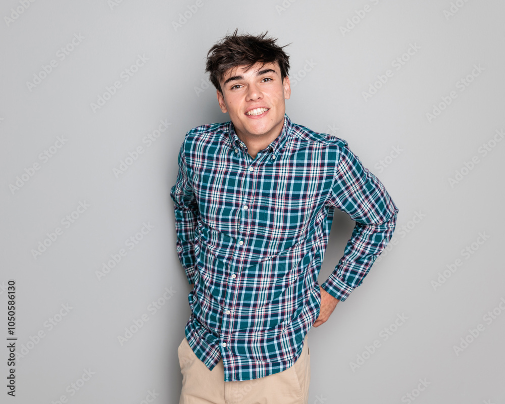 sexy young guy in plaid shirt adjusting pants and smiling sexy young guy in plaid shirt adjusting pants and smiling
