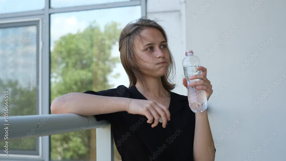 portrait of a young beautiful woman drinking water from a bottle on a sunny summer day portrait of a young beautiful woman drinking water from a bottle on a sunny summer day