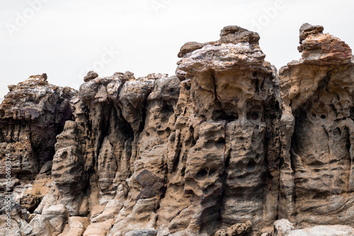 A stone wall made of strange stones, riddled with holes