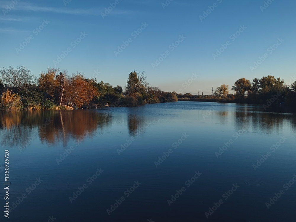 Autumn river shore landscape, calm panoramic view, blue and brown, water reflection Autumn river shore landscape, calm panoramic view, blue and brown, water reflection