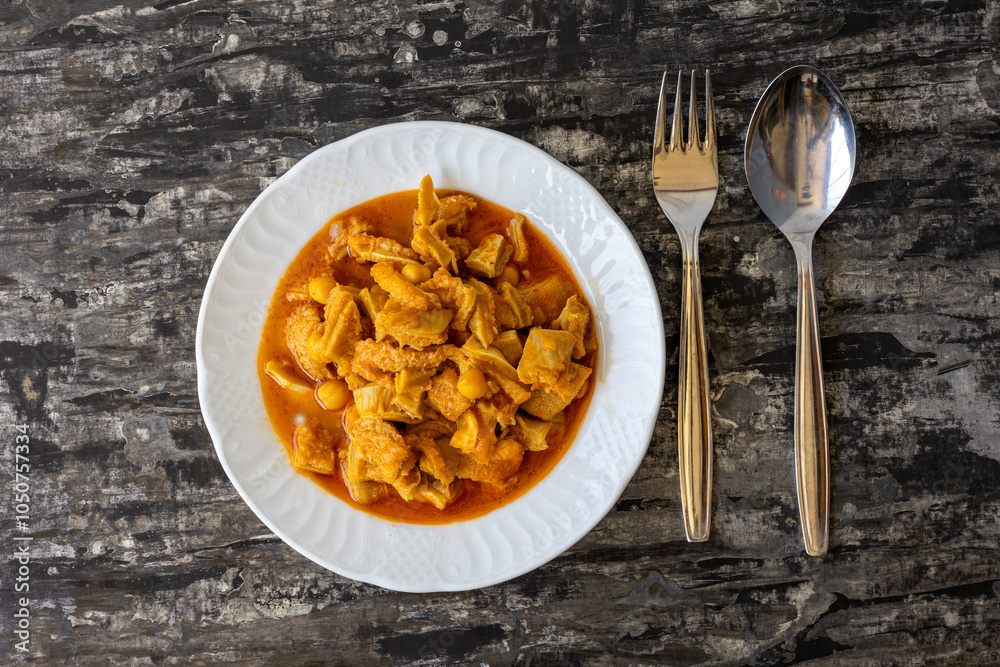 A dish from Turkish cuisine. Lamb tripe with chickpeas served on a white plate.