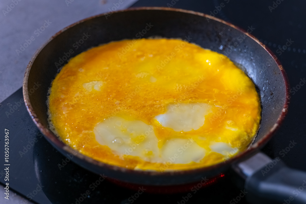 Eggs are cooking in a pan on a stovetop Eggs are cooking in a pan on a stovetop