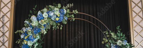 Elegant blue and green floral archway backdrop for wedding ceremony or special event   