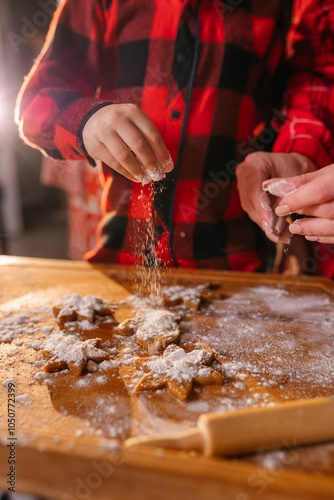 Cooking Christmas cookies with family. Father Mother and daughter hands top view on making gingerbread biscuits with cookie cutters, with New Year Christmas decoration
