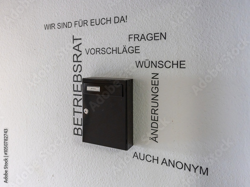Foto Das Bild zeigt einen schwarzen Briefkasten an einer Wand