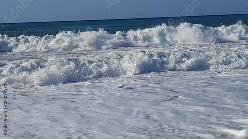 footage of foaming waves crashing noisily on a sandy beach on the island of Crete in Greece in august 2023