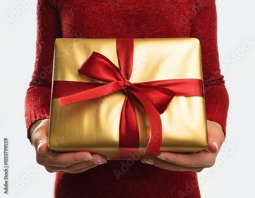 Woman holding a golden Christmas gift box with a red bow and ribbon, giving Chrsitmas presents photo