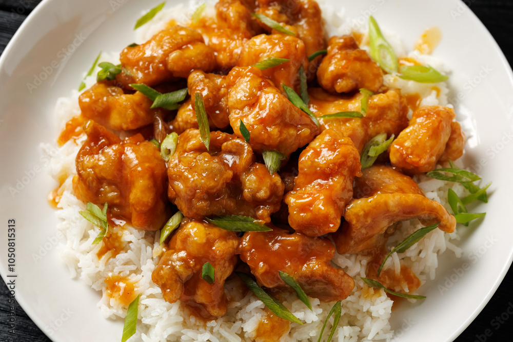 Chinese orange chicken with rice and green onion garnish Chinese orange chicken with rice and green onion garnish