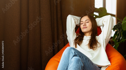 Break from work concept. Girl freelancer with closed eyes relaxing on bag chair photo