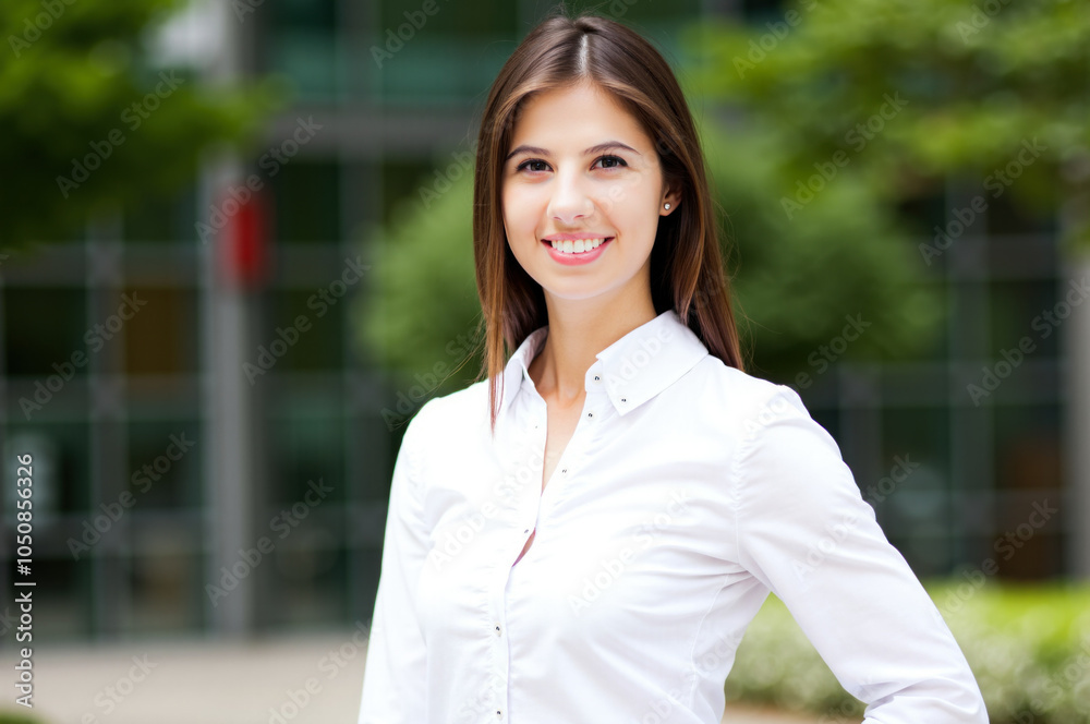 Smiling businesswoman posing outdoors in urban setting Smiling businesswoman posing outdoors in urban setting