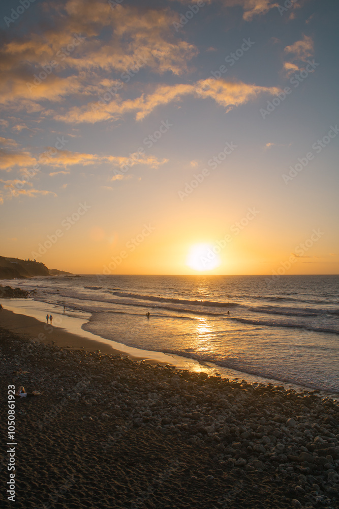 Strandspaziergang bei Sonnenuntergang mit goldenem Himmel und sanften Wellen Strandspaziergang bei Sonnenuntergang mit goldenem Himmel und sanften Wellen