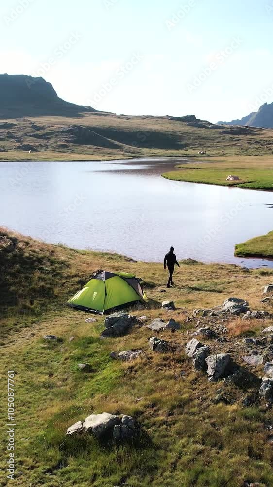 Acampada en un lago de las montañas. Plano orbita drone.