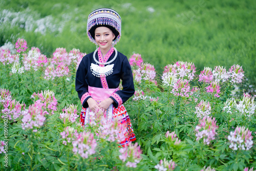 Obraz na płótnie Beautiful portrait fashion of Akha hill tribe girls wearing traditional costumes happily relaxing in a lovely flower garden is a travel destination in autumn at Chiang Mai, Northern, Thailand