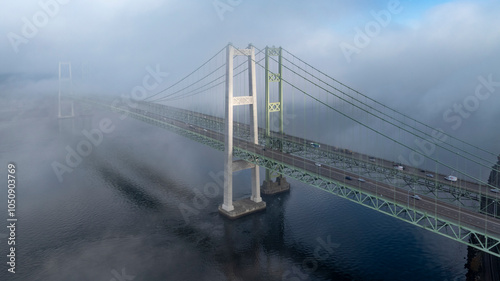 Morning fog over the Tacoma Narrows Bridge while the sun is breaking through