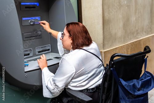Woman in Wheelchair Utilizing City ATM for Banking photo