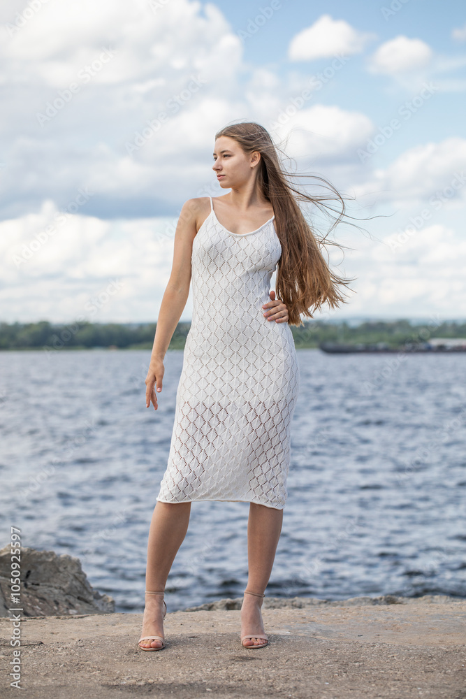 Portrait of a young beautiful blonde woman in a white summer dress Portrait of a young beautiful blonde woman in a white summer dress