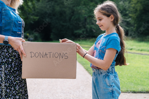 Young girl putting stuff into a donation box