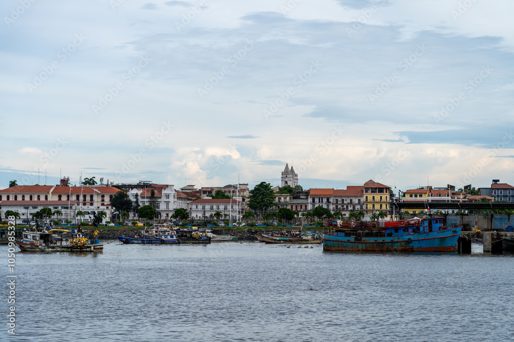 View towards Casco Viejo from the water, with barge and boats in front of old buildings View towards Casco Viejo from the water, with barge and boats in front of old buildings