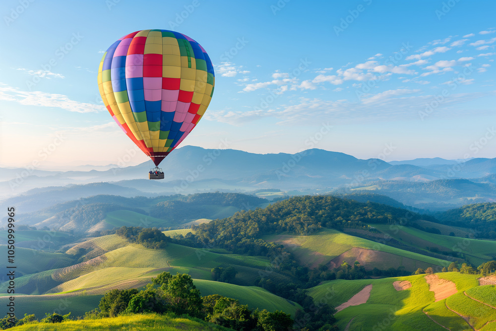 Obraz premium A colorful hot air ballon floating above the green hills at sunrise, symbolising freedom and adventure in travel and vacation planning.