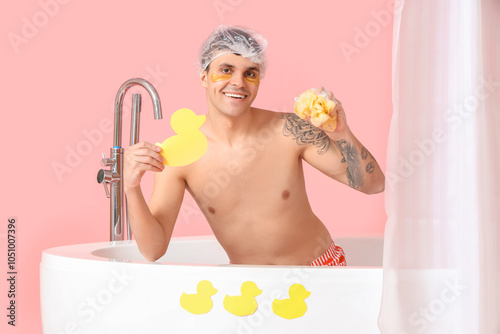 Young man in bathtub with p...