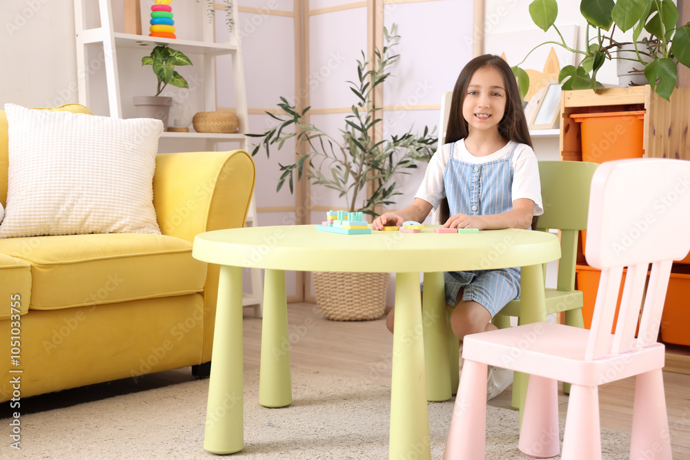 Cute little girl with building blocks on table at home Cute little girl with building blocks on table at home