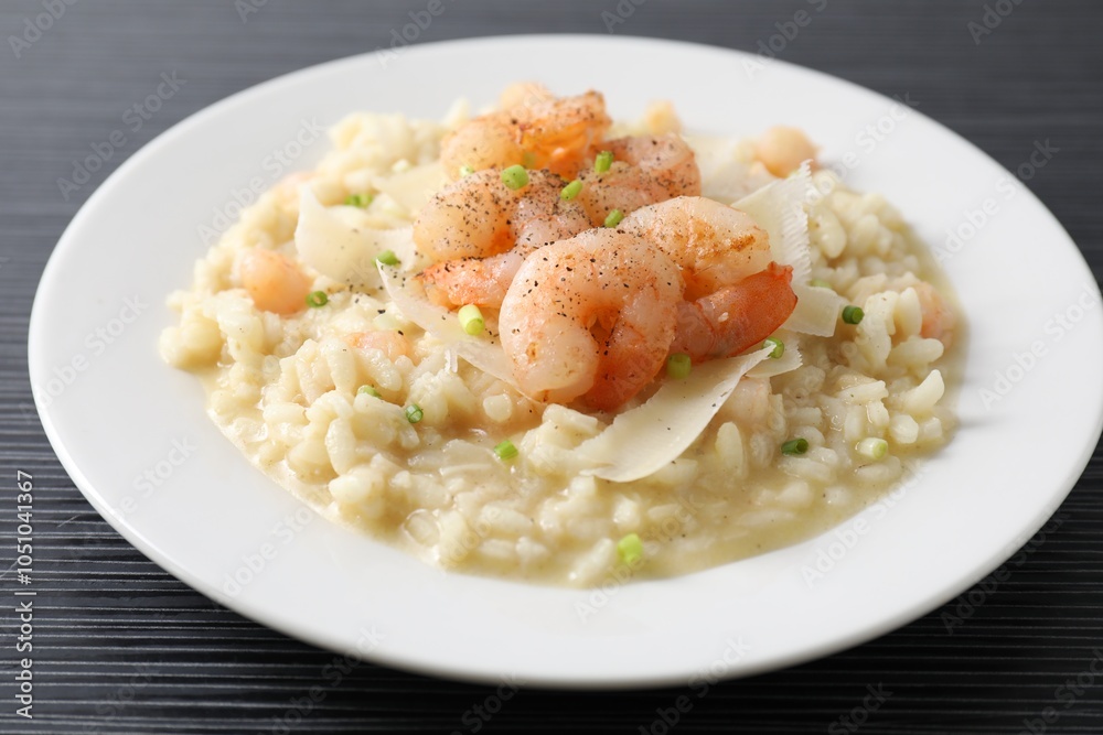 Delicious risotto with shrimps and cheese on black table, closeup Delicious risotto with shrimps and cheese on black table, closeup