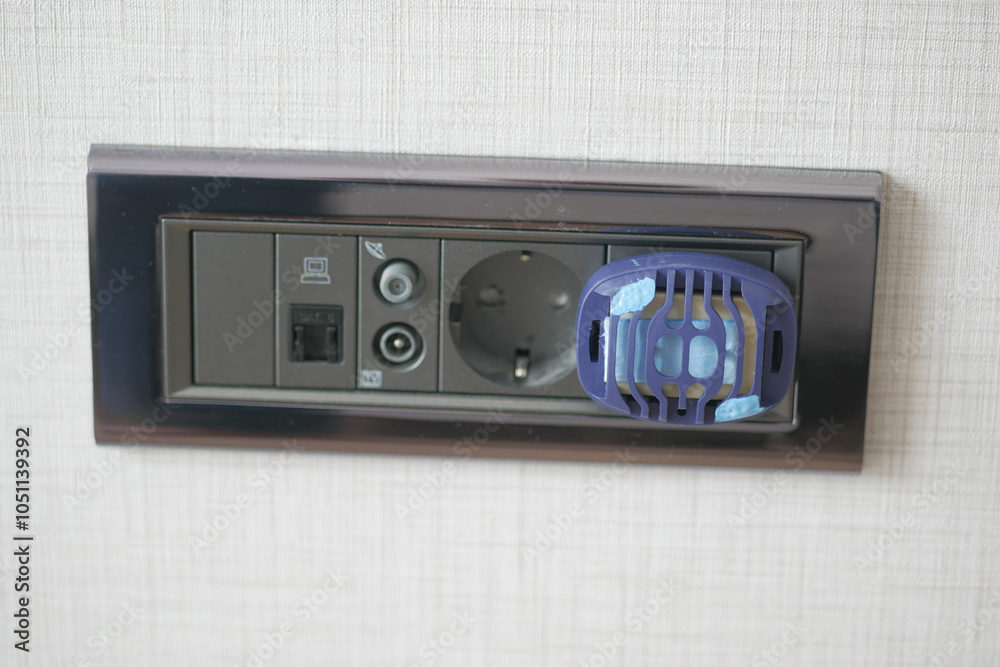 Obraz premium Close-Up of Electric Plug with Insect Repellent Device