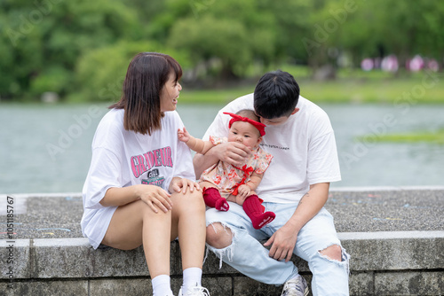 A Taiwanese couple in their 20s and their 7-month-old baby celebrate a birthday in a vast green park in Yilan County, Taiwan. photo