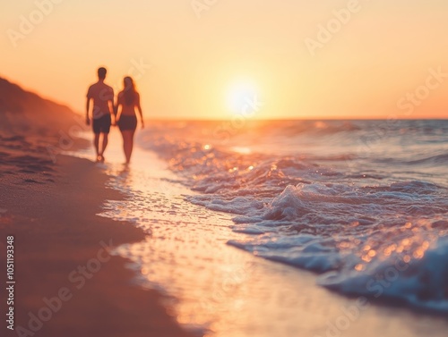 Couple walking hand in hand along the beach at sunset. photo